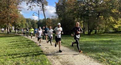 Zdjęcie przedstawia biegnących uczestników biegu przełajowego, którzy tuż przed chwilą wystartowali.
Każdy z uczestników jest bardzo uśmiechnięty i pełen energii.